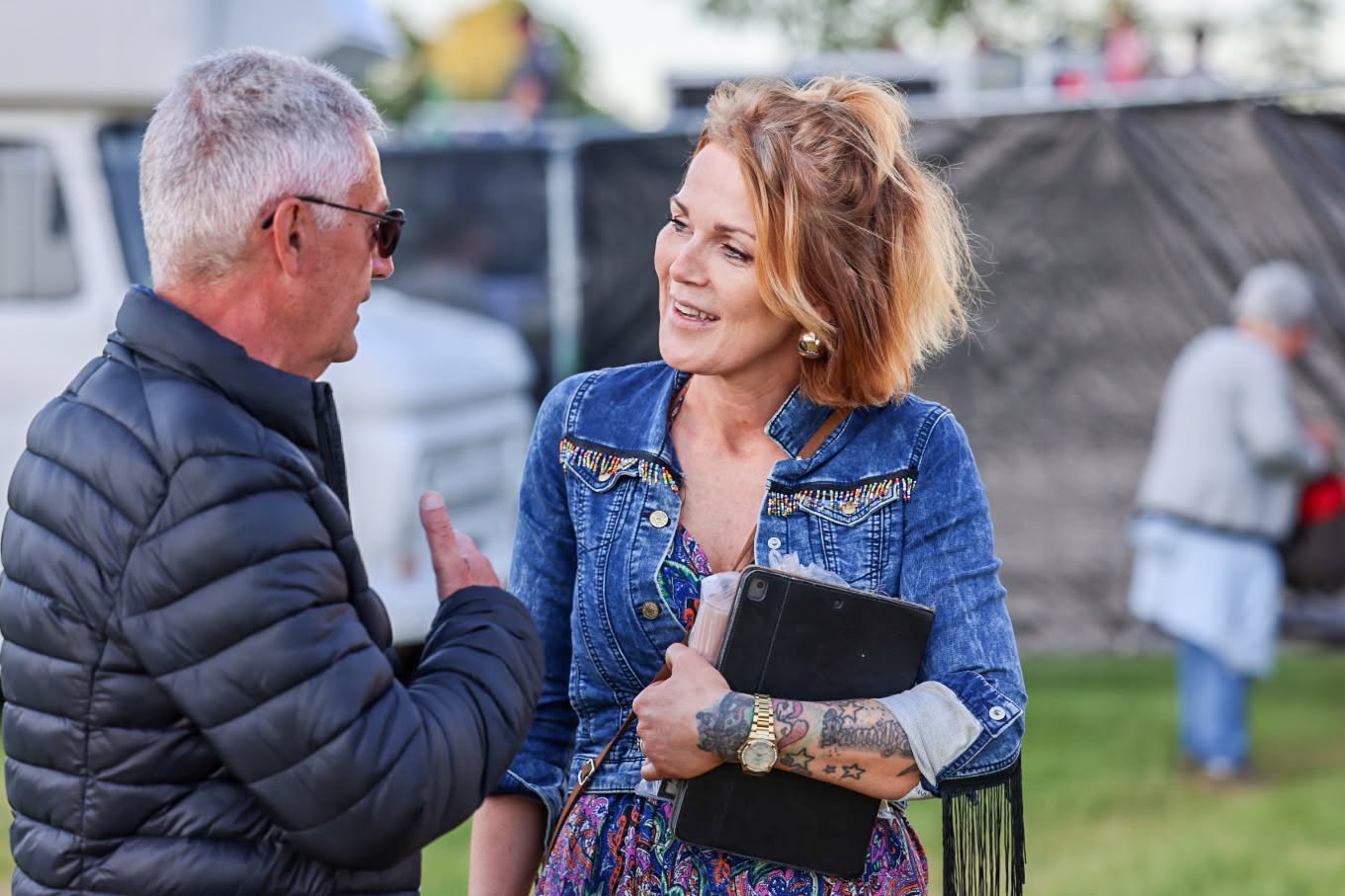 Herborg Torkilsdóttir i samtale med en mand på en udendørs festivalplads
