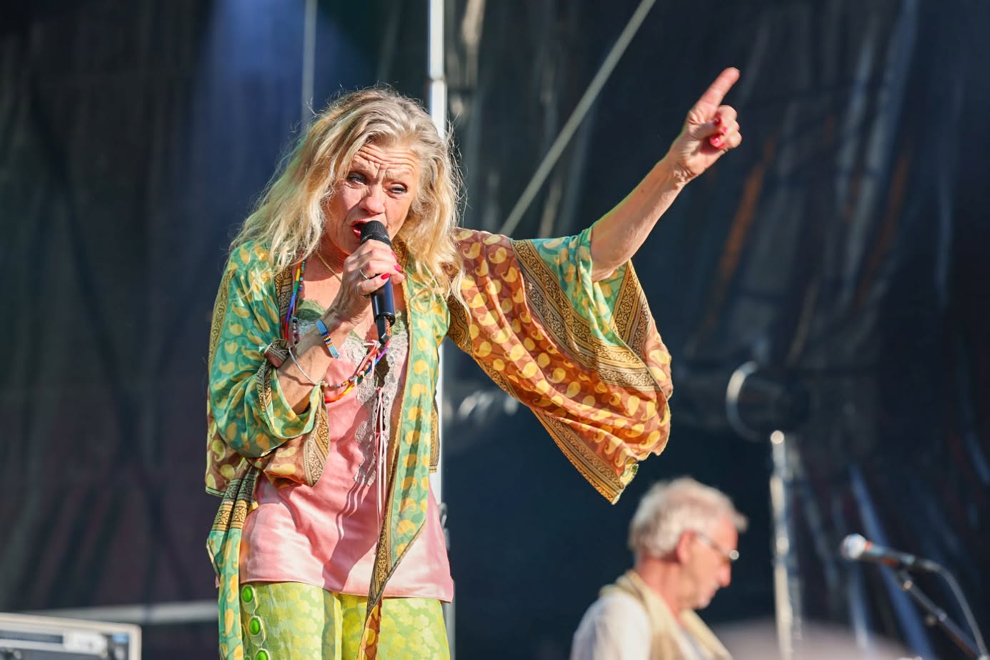 Pernille Højmark synger med mikrofon og løftet arm på scenen